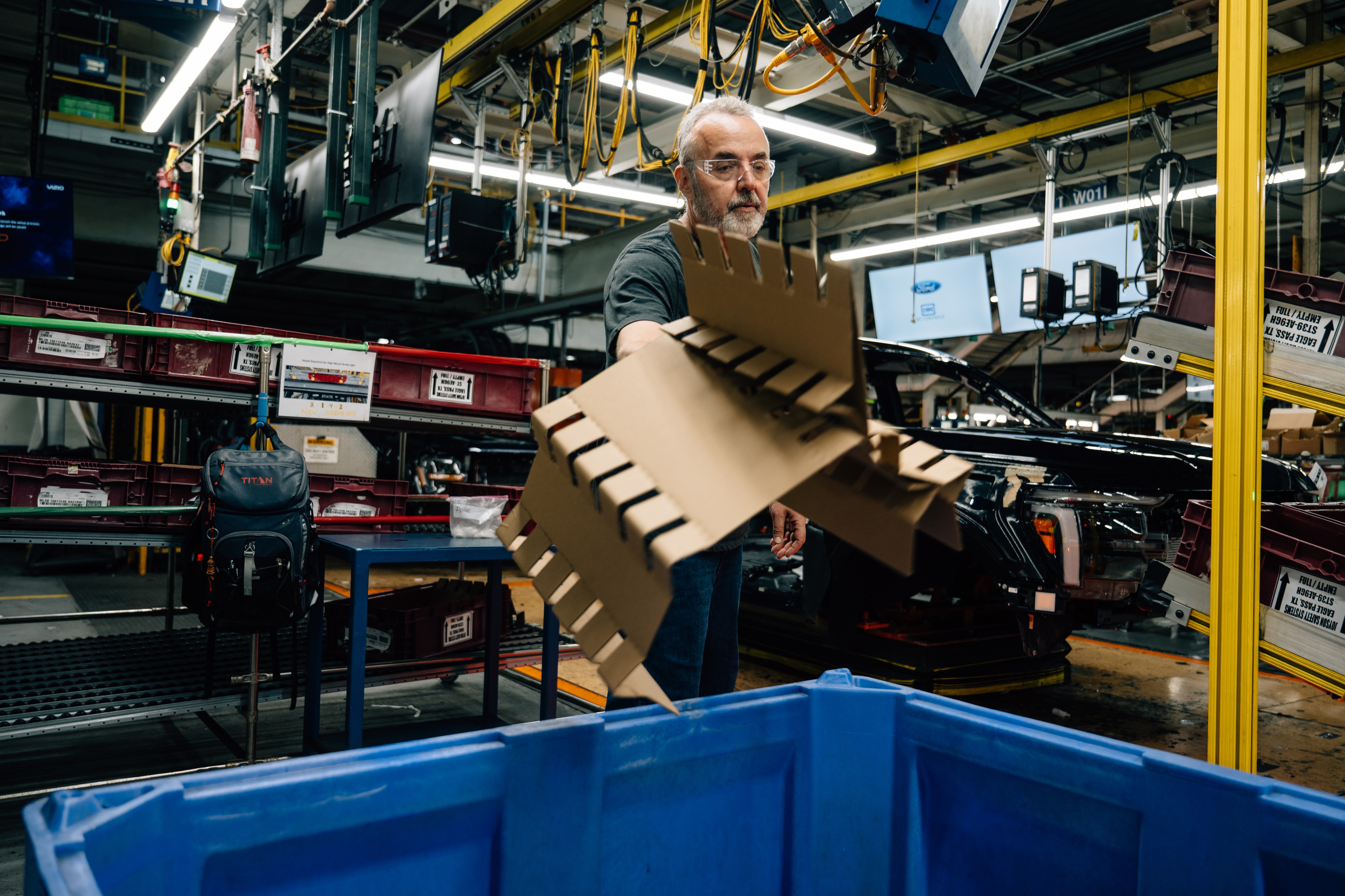 Dearborn Truck Plant employee Hussein Makled sorts cardboard into a recycling bin on the plant floor.